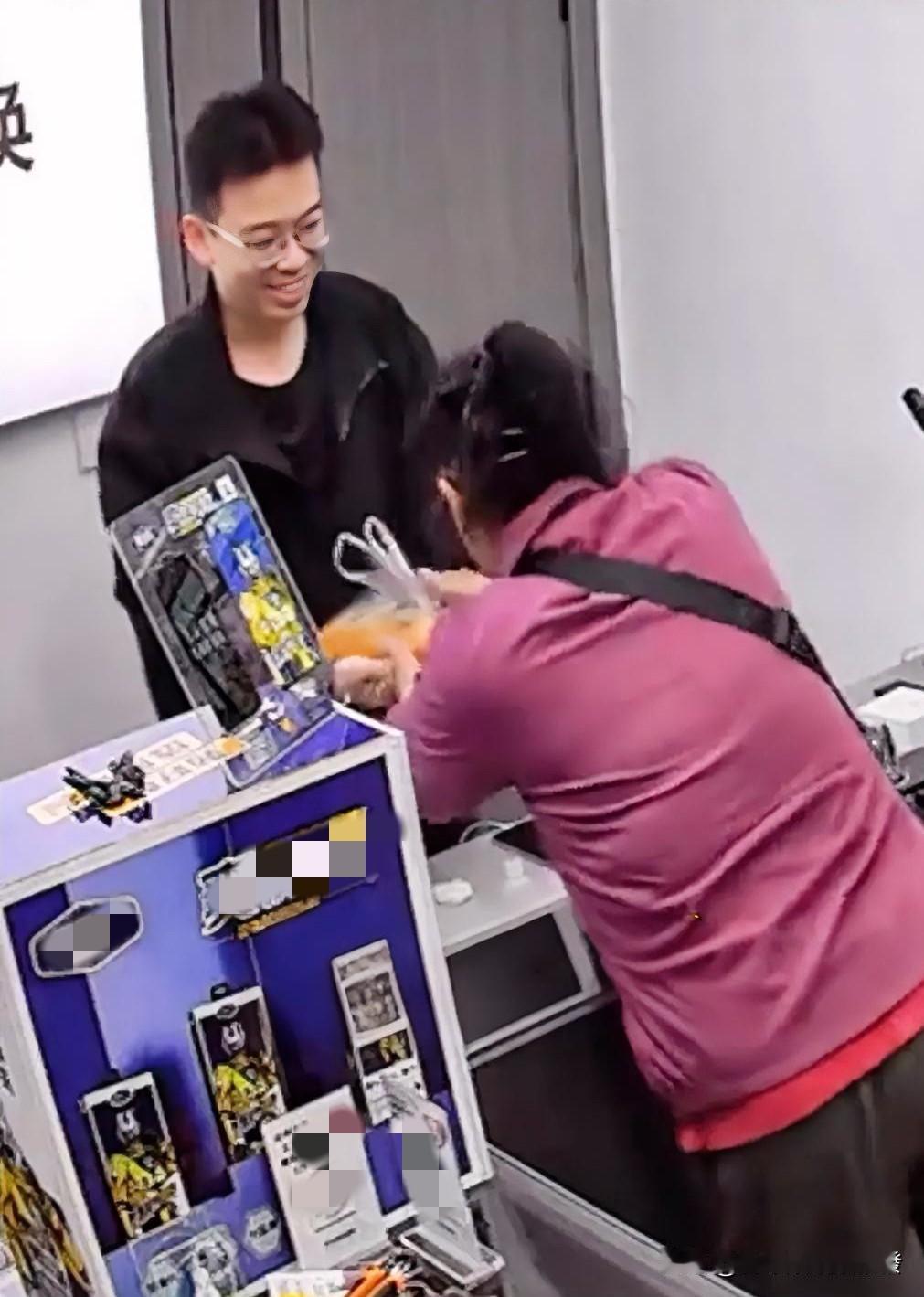 一位阿姨走进一家店里，年轻的店老板热情地打招呼，阿姨提着几个大大的橙子要让他尝尝