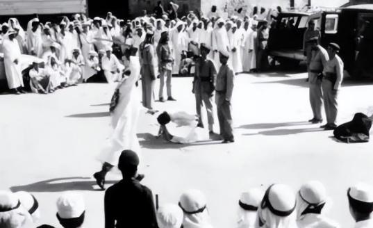 这是1977年沙特王室处死公主米莎尔和她的情人的老照片，照片中一袭黑袍已经倒地死