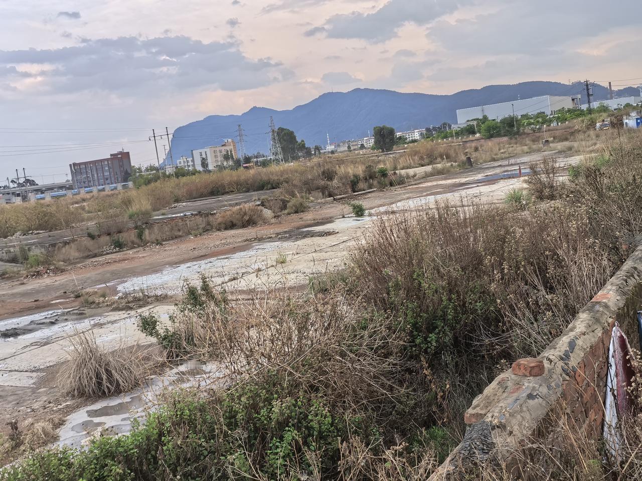 昆明西客站，在地铁3号线石咀站旁边，正基春天里边上。
今天刚刚去看了，还是杂草丛