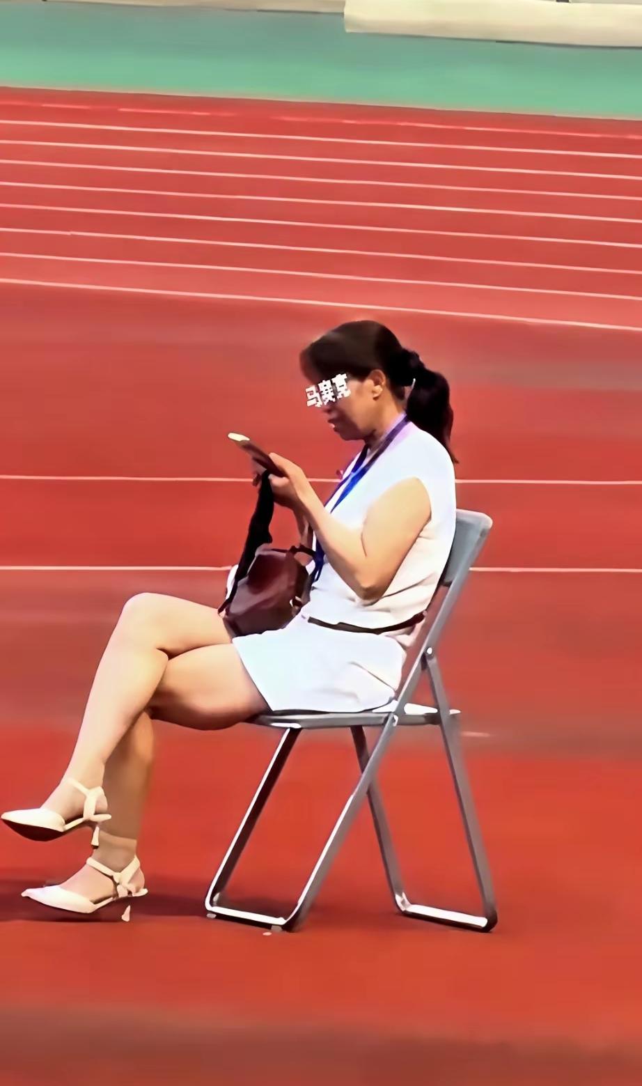 全网都在找这个甘肃陇超的女子是谁，她坐在一张椅子上，翘着二郎腿，刷着手机，脖子上