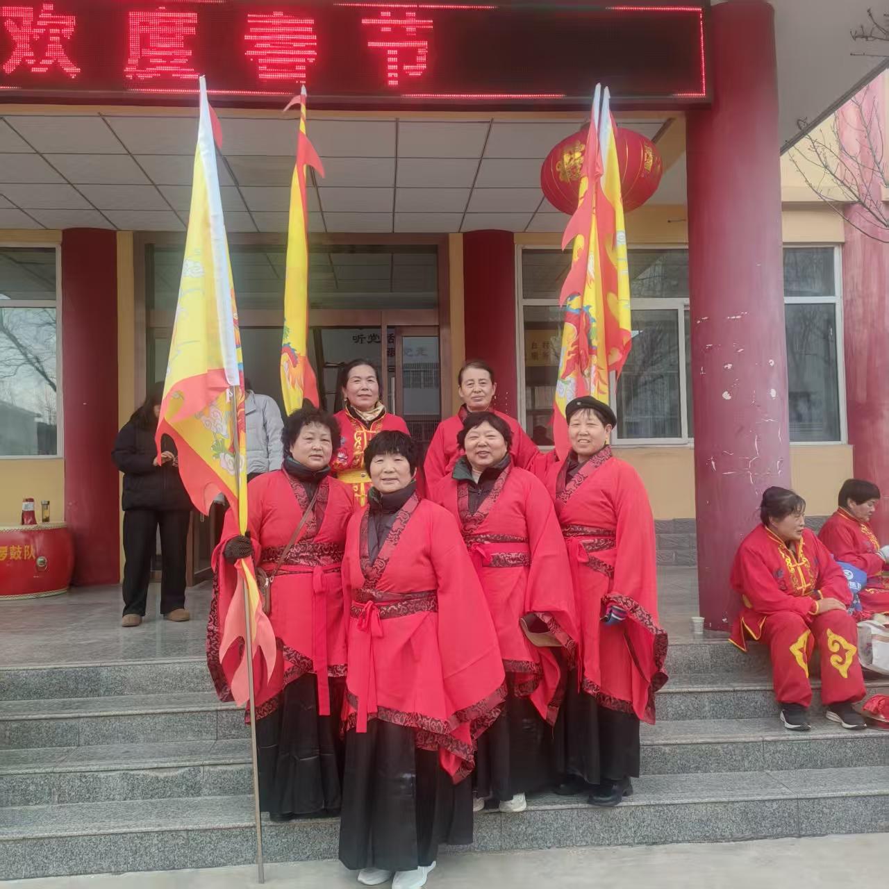 2. 新春盛景映红妆，旗影招展喜气扬。我们身着盛装站在春光里，把对生活的热爱，都