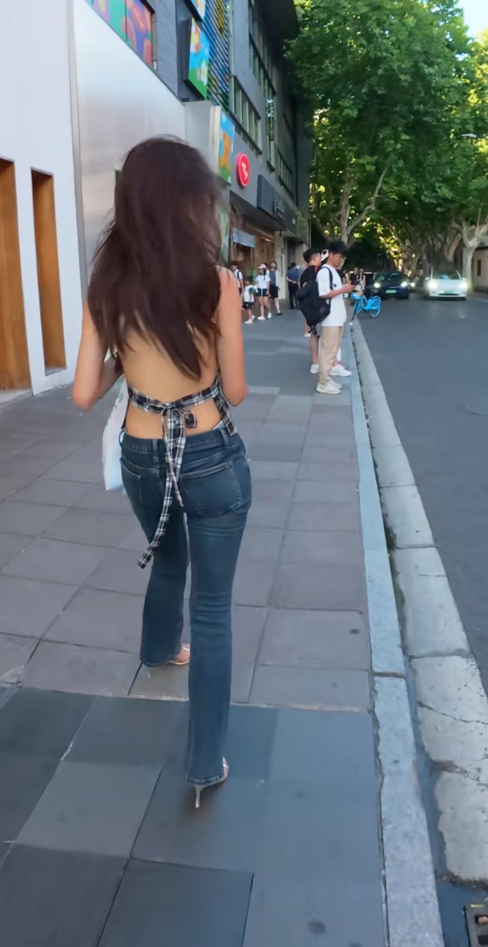 梧桐叶影里的上海街头，风都在为她放慢脚步。露背衫配微喇裤，是独属于沪上的松弛时髦