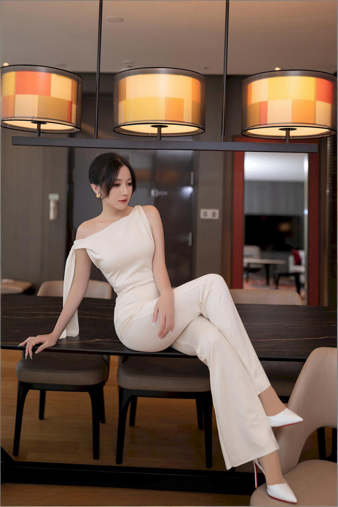 米色丝质上衣随风轻扬，同色系阔腿长裤衬得身姿愈发修长挺拔。三寸白色高跟鞋清脆地叩