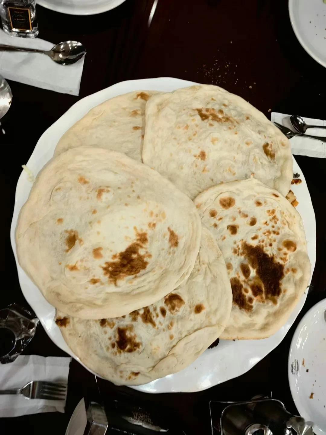 在巴士拉一家网红店吃此行伊拉克段的晚餐，几张大饼下是一大盘烤肉拼盘。考虑到伊拉克