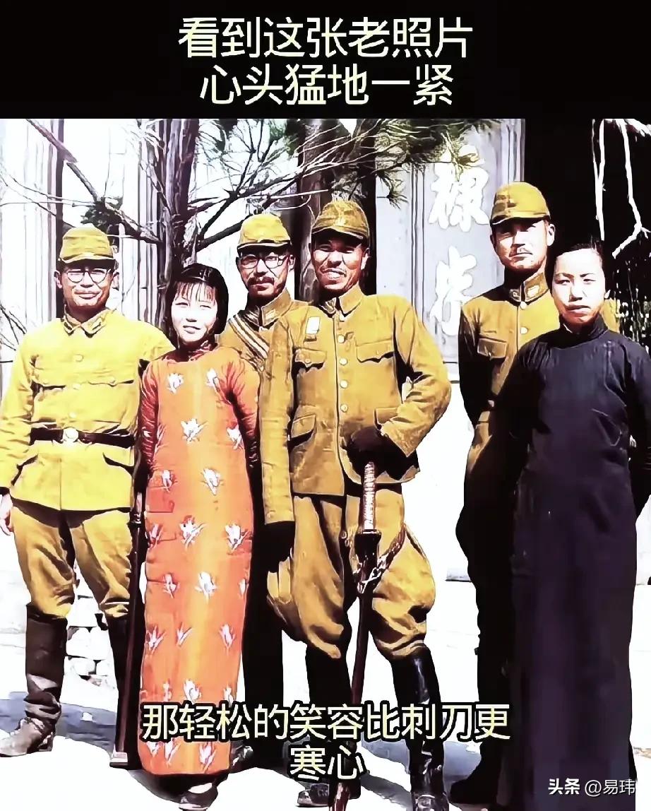 一群日本军官和一名汉奸胁迫一位穿着长褂的女孩一起摆拍，虽然女孩和日本军官都在笑，