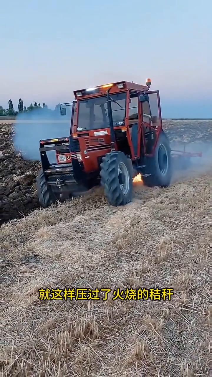 这拖拉机的师傅也太大胆了，竟然开着拖拉机就这样压过了火烧的秸秆。这操作真是太危险