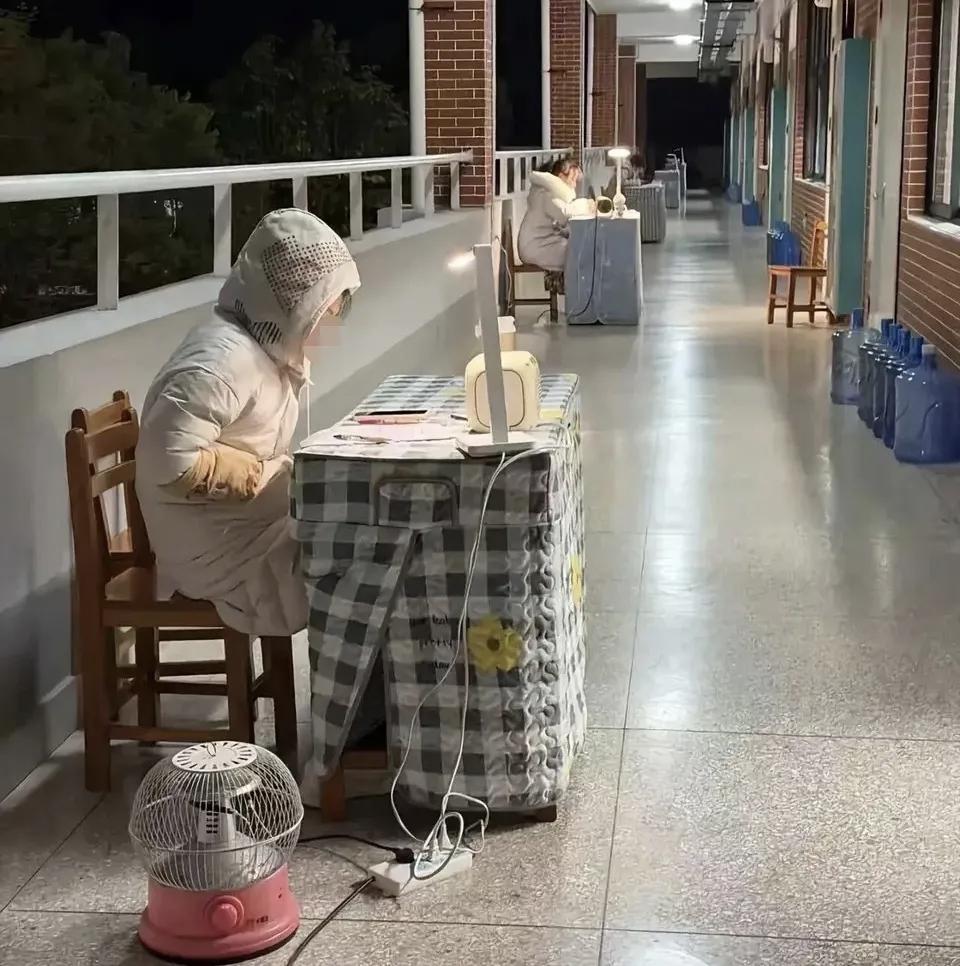 网上刷到，某学校晚自习，老师在走廊办公。
每个教室门口，桌椅，台灯，小太阳，穿着