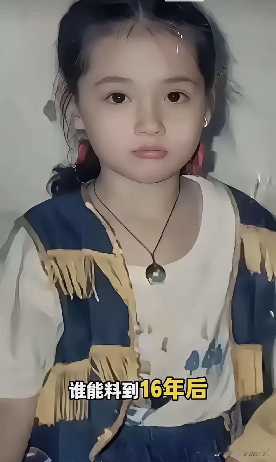 这是拍于九十年代的一张照片，照片中的小女孩扎着小马尾，留着一些小刘海，脸庞圆嘟嘟