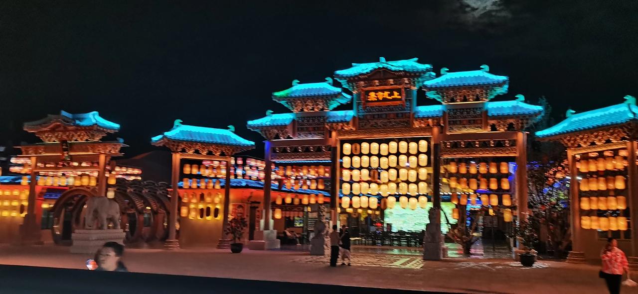 夜幕降临照敦煌，
星河灿烂映楼廊。
商声细语随风起，
灯影摇曳似梦长。

沙海遥