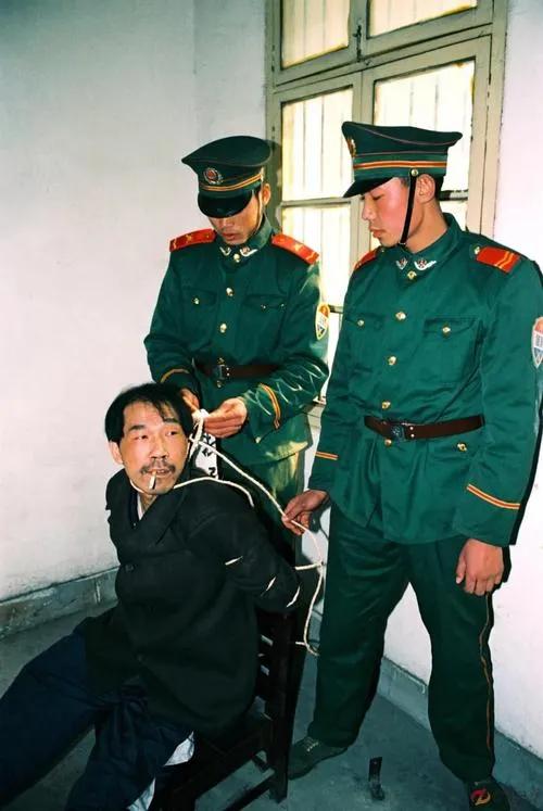 1999年12月，合肥看守所，法子英被枪决前，留下的一张老照片，他嘴里叼着烟，享