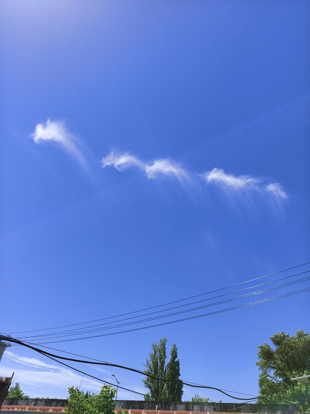 晴空万里，明媚的阳光倾洒大地。几朵白云悠然聚拢，竟幻化成一条腾飞的巨龙，这绝美的