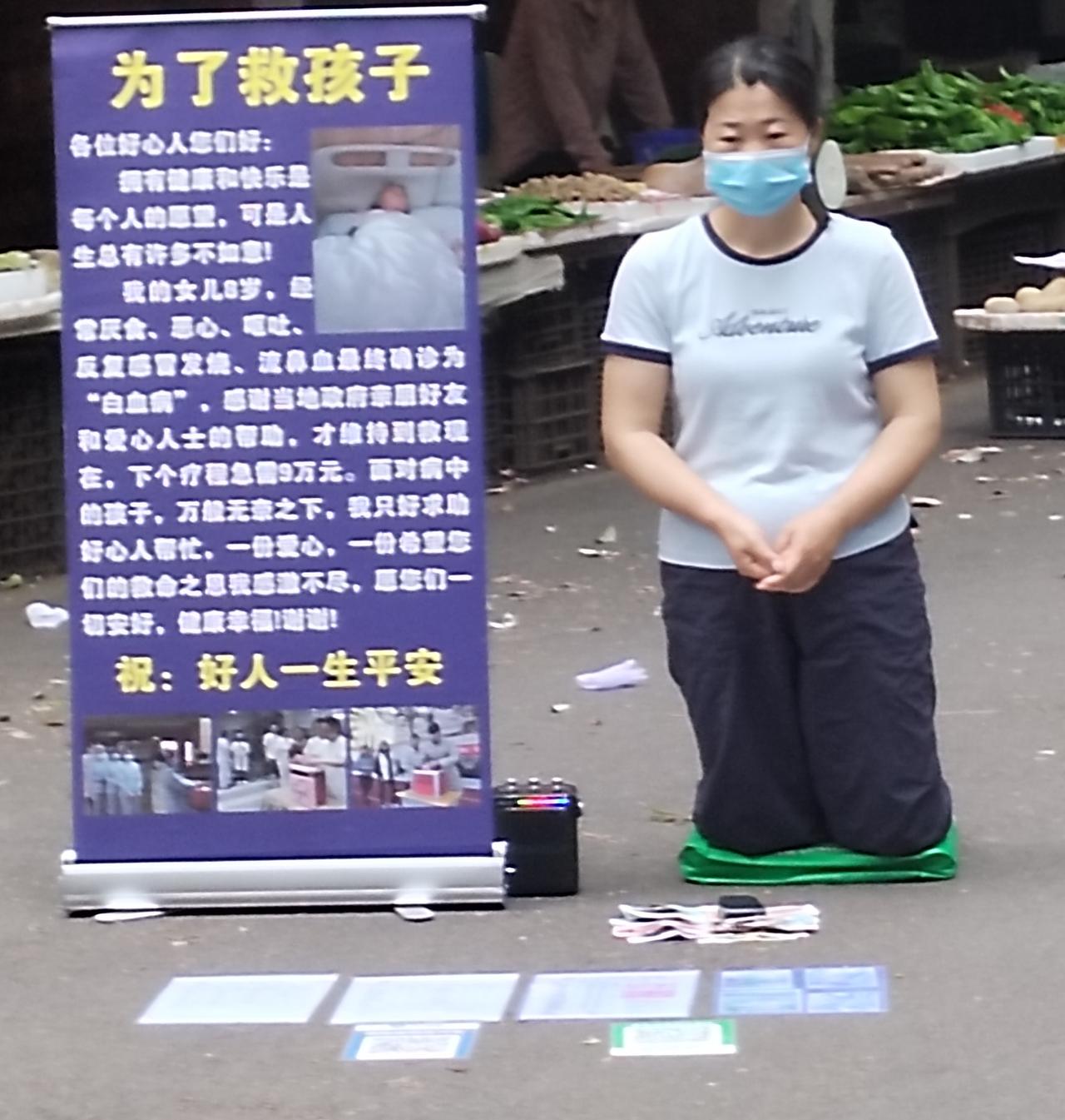 昨天早市上，有一名女子，估计年龄在三十岁左右，直挺挺的跪在地上，播放着施爰内容的