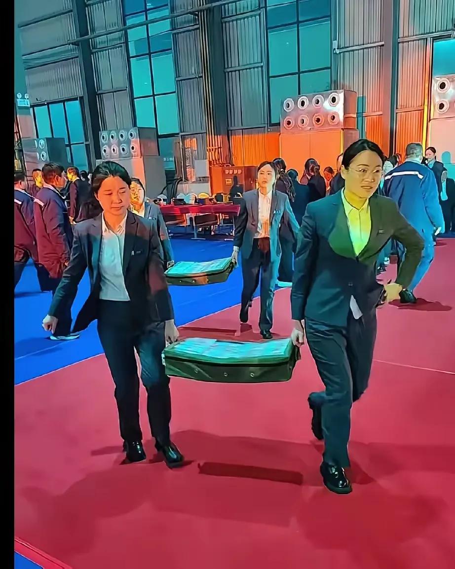 这是真的吗？河南煤炭老总正在
给员工发放过亿年终奖。看工作人员
抬钱上场，沉甸甸
