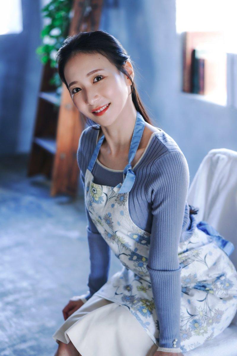 这姑娘笑得真甜，穿着围裙像是在准备做蛋糕。