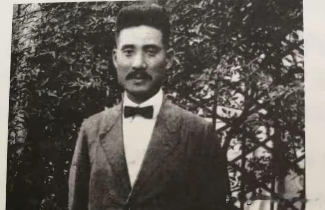 一张拍摄于1947年的南开中学操场旧照，张伯苓独自站在旗杆旁，身上那件藏青色长衫