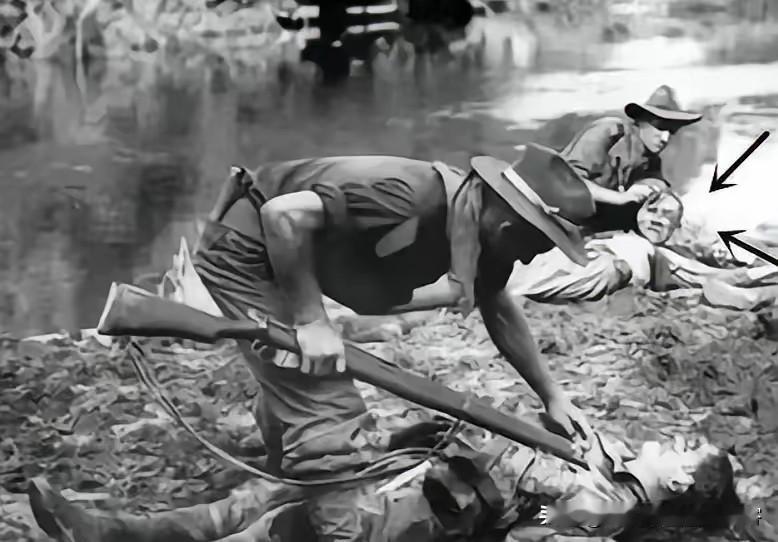 1945年文莱战场，两名澳军士兵在打扫战场，其中一人正怒割日军尸体的脸皮。这幕看