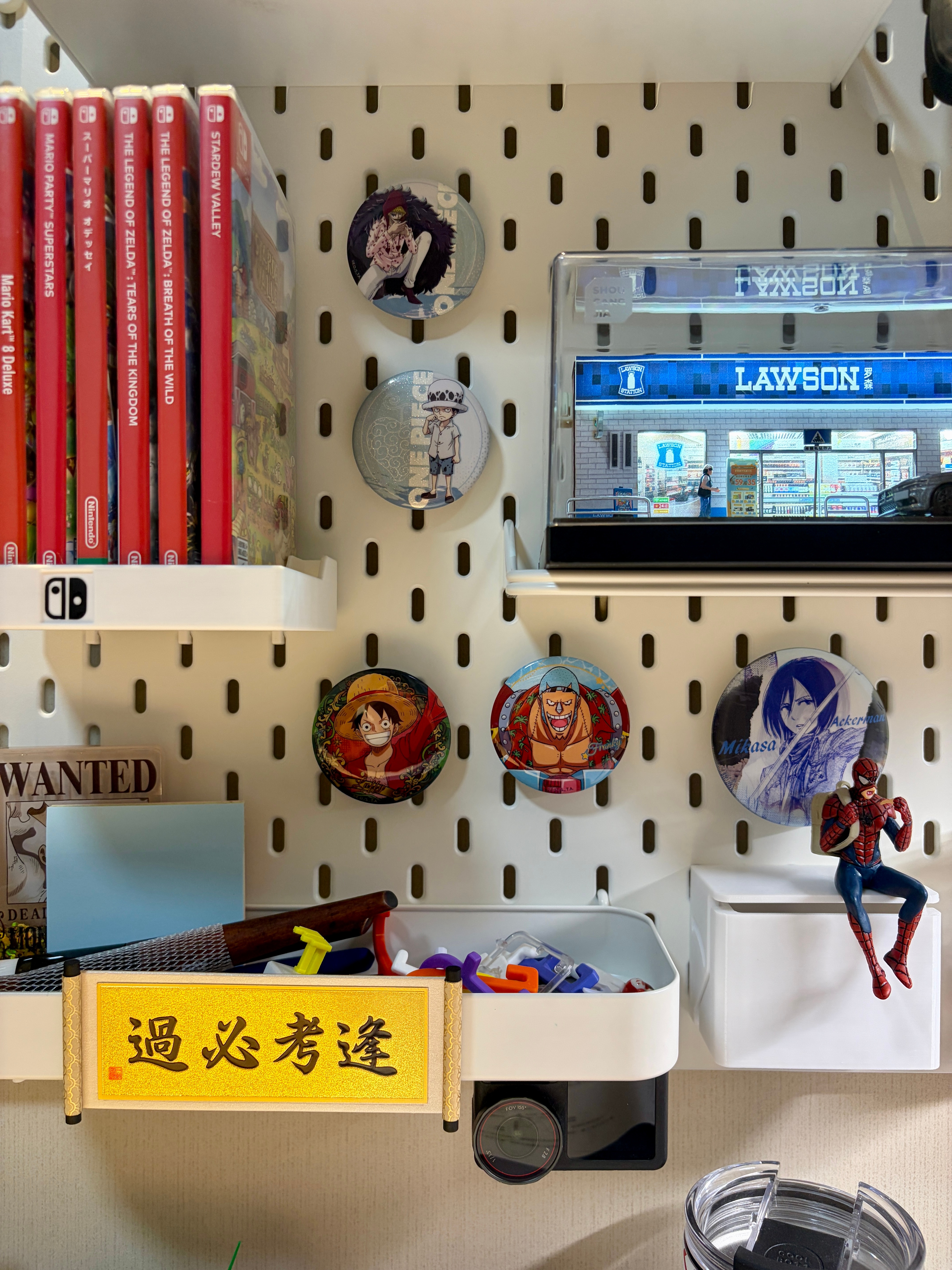 邻居一家去云南旅游，给阿福带了两个冰箱贴。阿福把“逢考必过”放在书桌前的洞洞板上