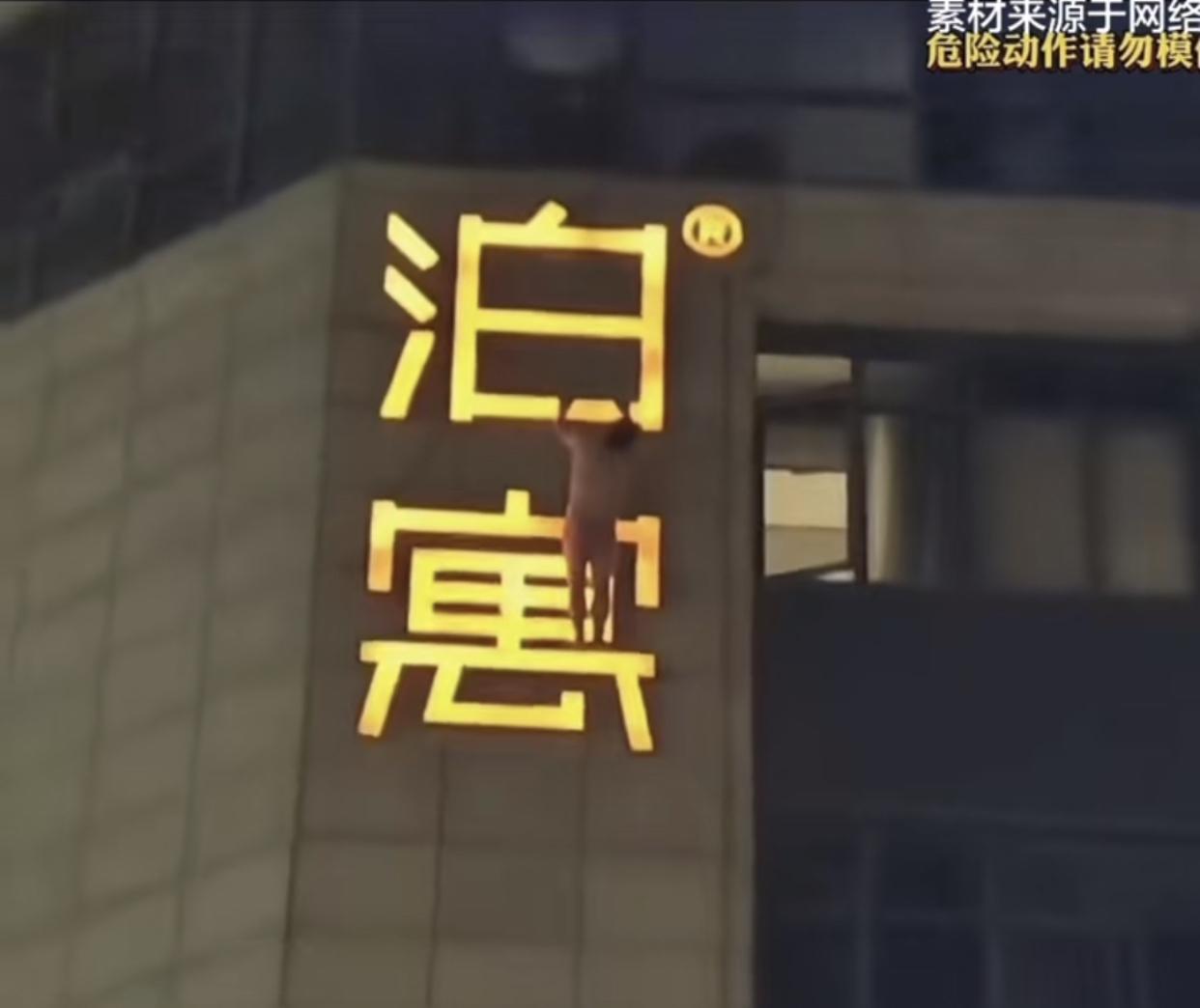 有网友拍到某酒店外的广告牌上赫然站着一个只穿了裤衩子的男子，他双手紧紧的“泊”字