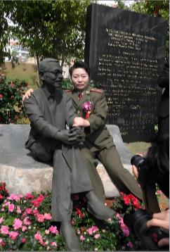 1997年，陈景润的夫人坐在丈夫的雕塑旁边，搂住“丈夫”的肩膀，留下了这张令人垂