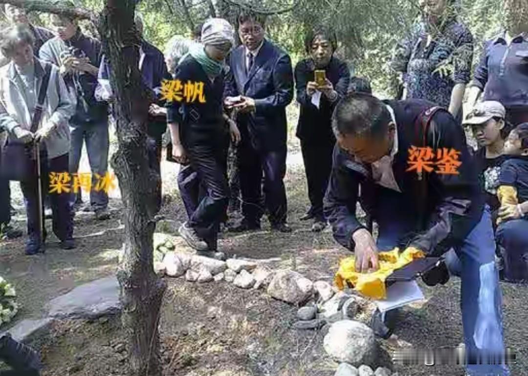 这是梁从诫先生树葬现场的珍贵影像，林间草木繁茂，氛围庄严肃穆。
其子梁鉴俯身放置
