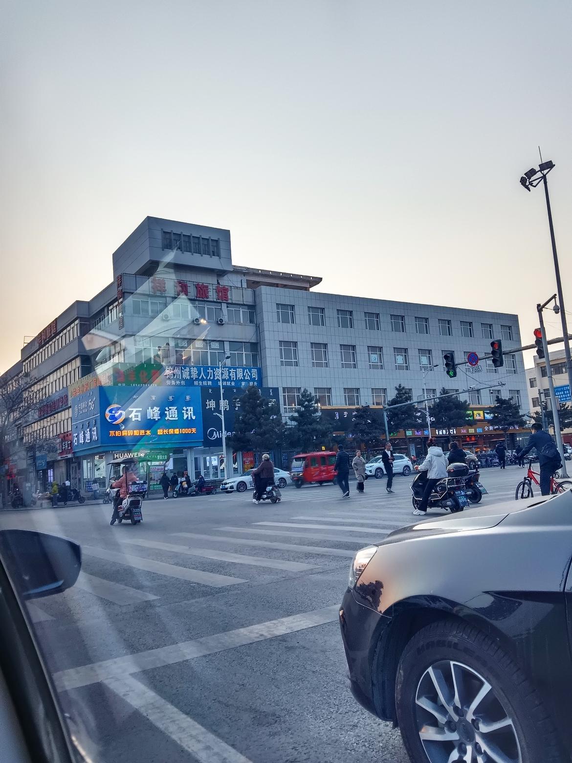 黄昏时分，车水马龙的城市街景，行人匆匆，灯火阑珊。