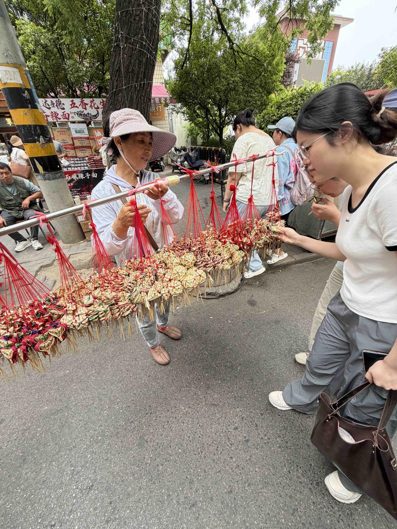 昨天上午，我经过西安洒金桥，看到一位南方大妈，提着挂在一根木棍上的，几大串香包在