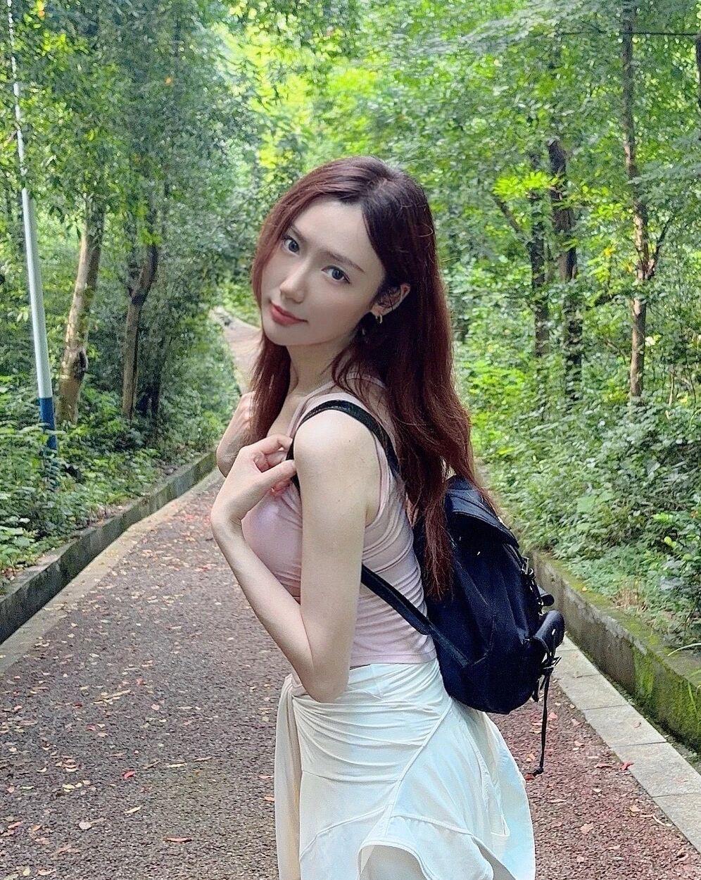 一个女孩背着包在林间小路上散步。