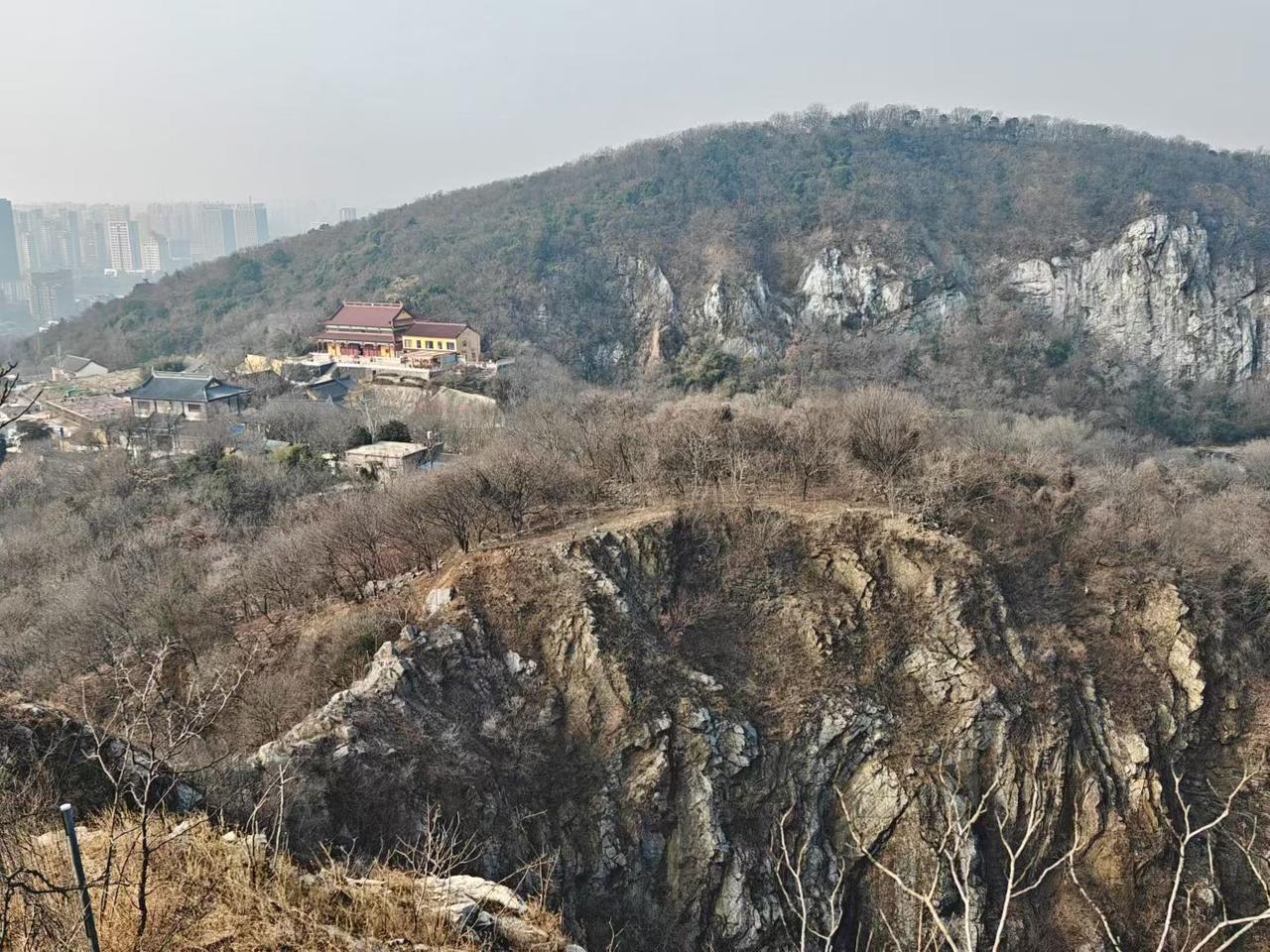 山峦驮着寺庙，在枯木与岩石间静立，城市的轮廓在雾里朦胧，像尘世与禅意，隔着层薄纱