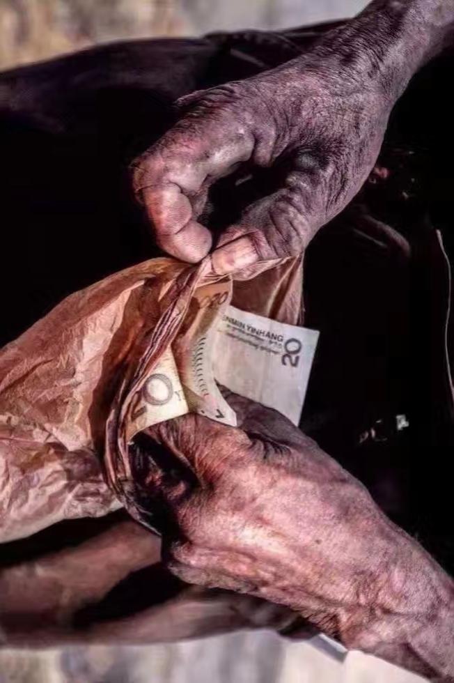 岁月沧桑，双手紧握20元，见证生活的艰辛与希望。