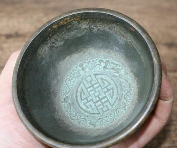 1972年，北京一清洁工清理着街上的一处公厕，由于许久未曾清理，老人家一手掩面，