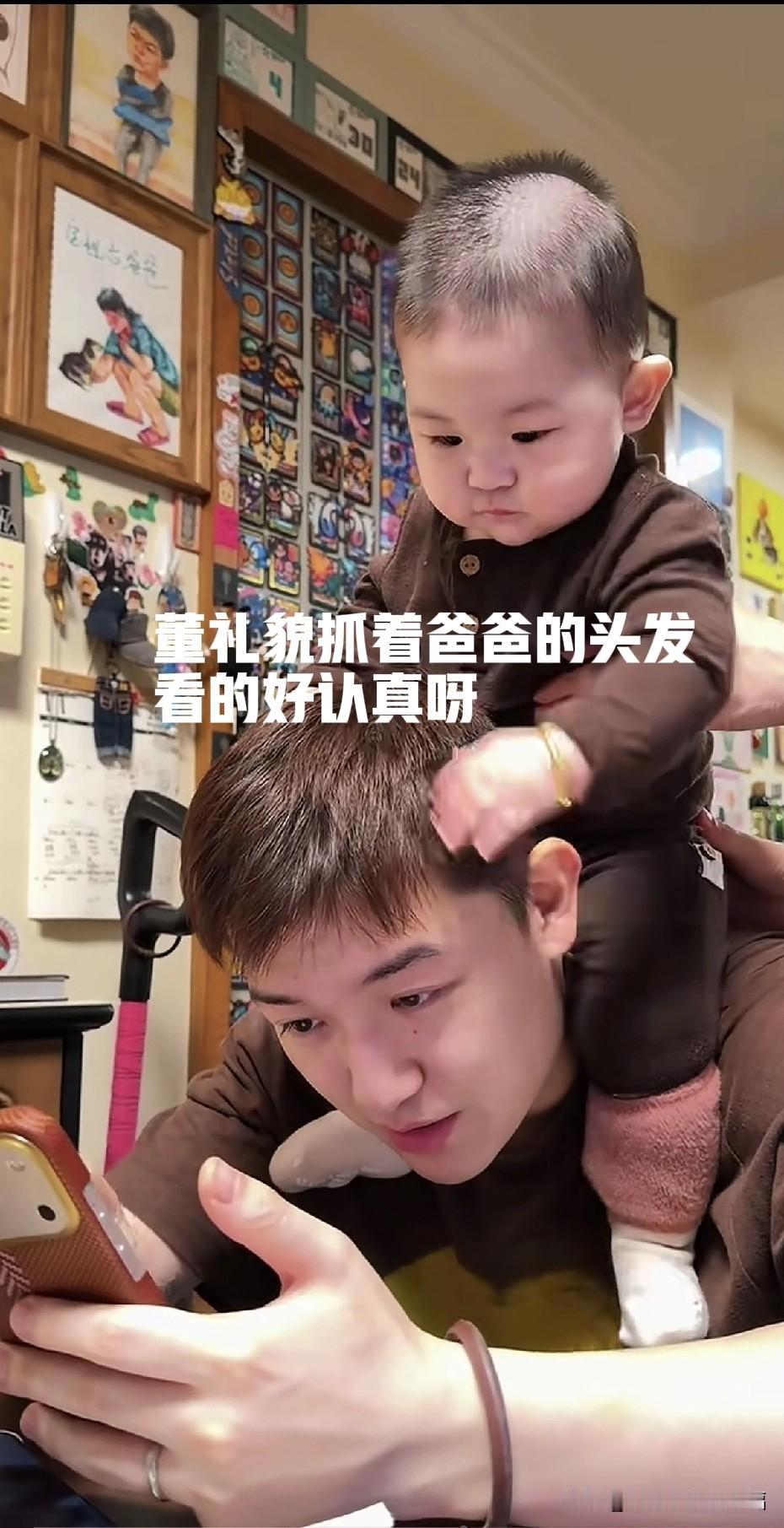 时间过得真快！董礼貌小朋友都可以坐在爸爸的肩头了，深咖色的亲子装让董礼貌看起来像