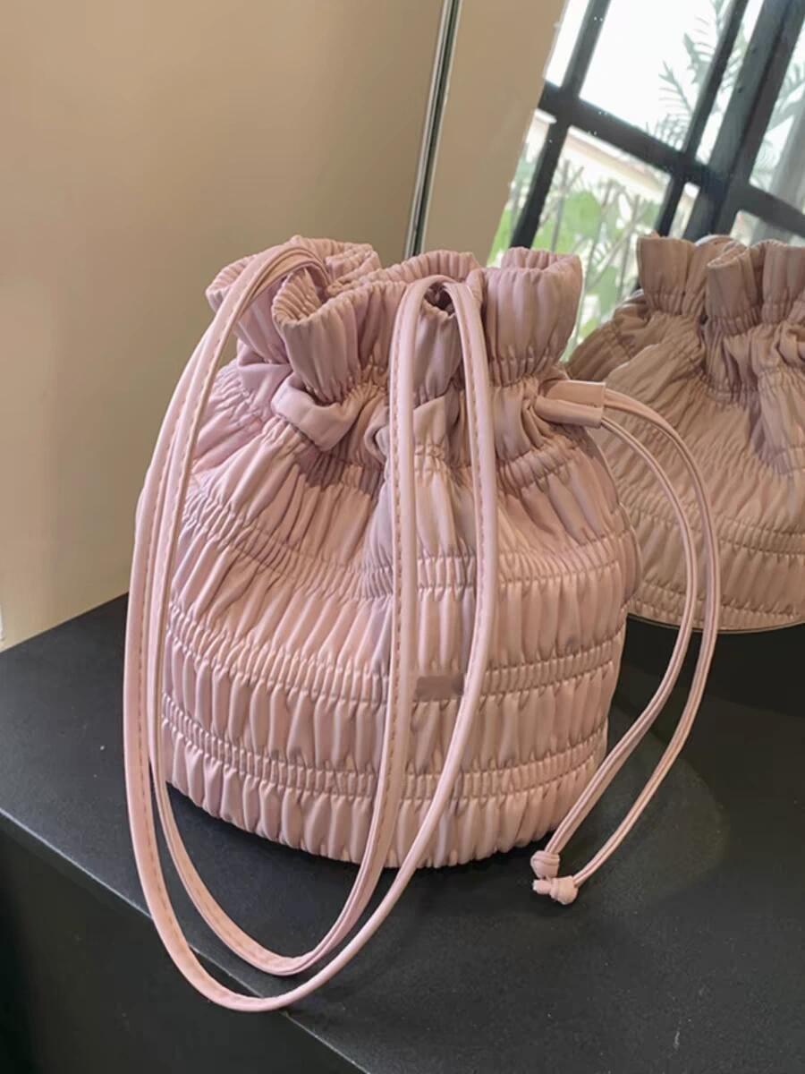 这个粉色褶皱水桶包堪称夏日宝藏单品，柔雾粉调温柔甜美，褶皱面料质感高级又小众，腋