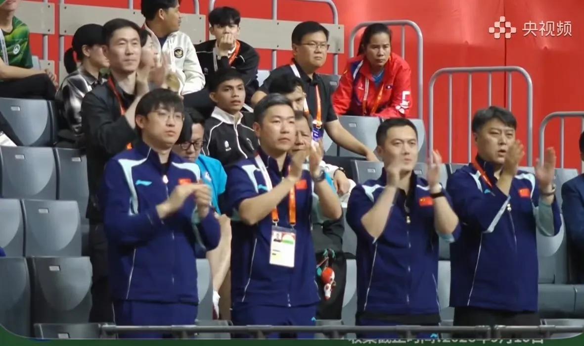【领队吃完饭，来到看台上，观看男团比赛】王励勤，乒协主席，专程来到看台观战这场男