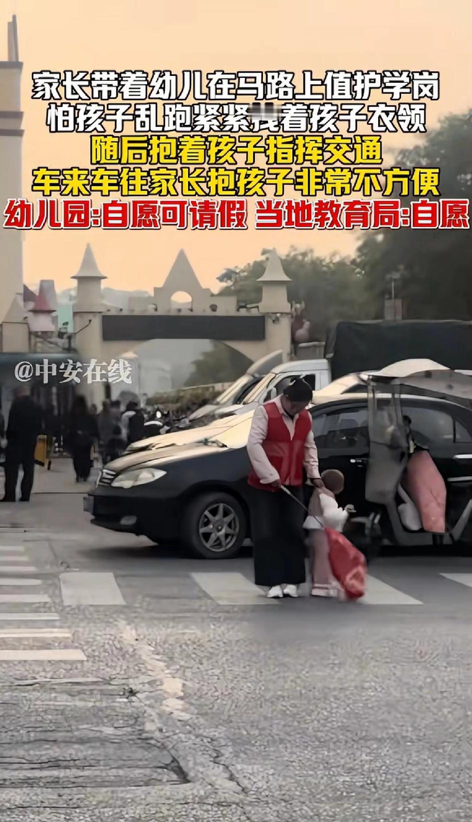 家长带着幼儿在马路上值护学岗怕孩子乱跑紧紧拽着孩子衣服，看到这位家长一刻也不敢放
