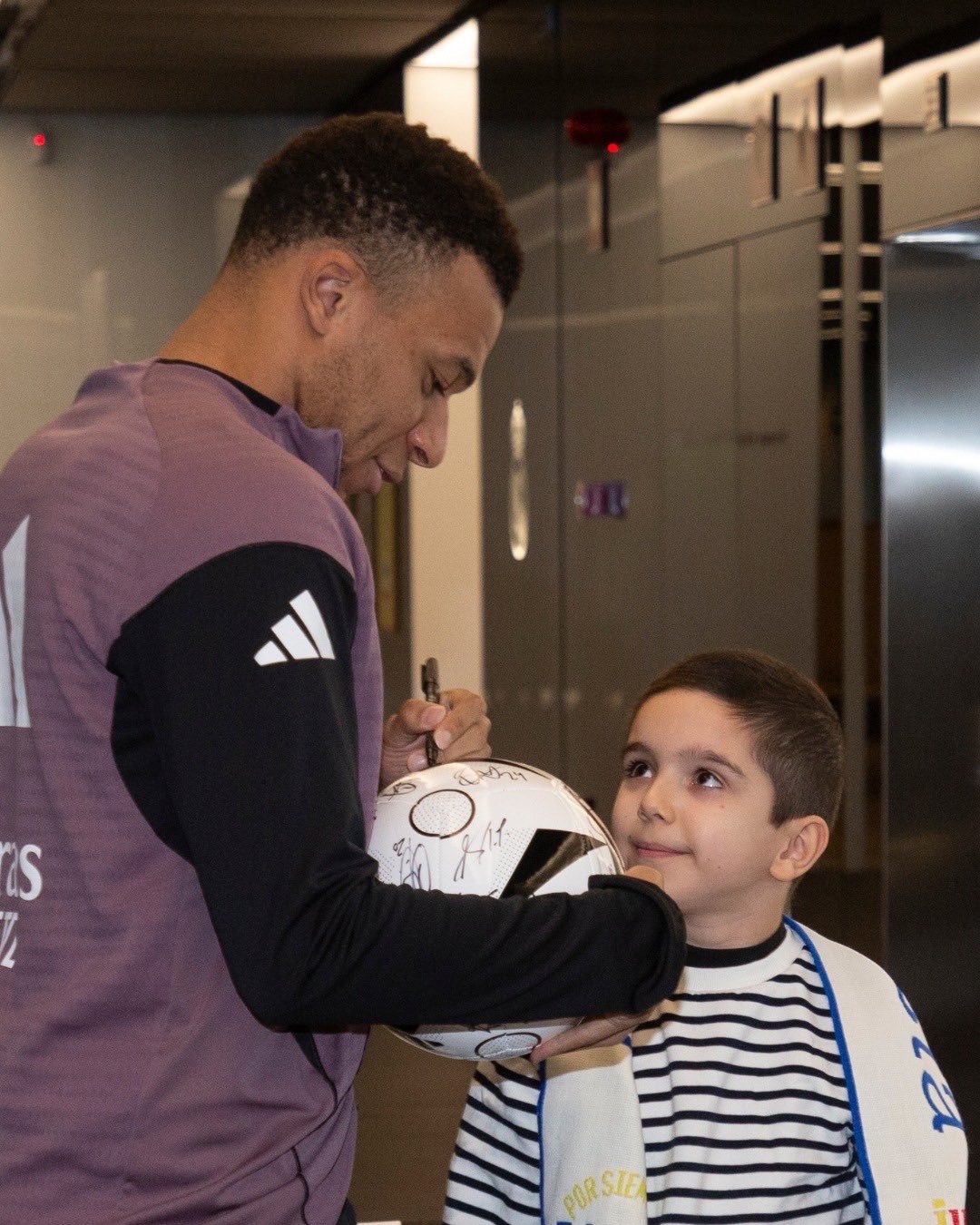 在训练场苦干一天的姆师傅看见小球迷 把手机往裤腰带里一塞就开始合影签名全安排 