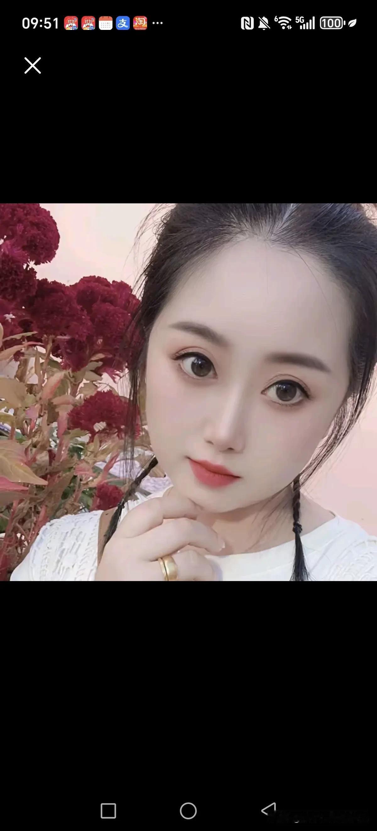 路过一片花丛，瞧见一位姑娘在里头摆姿势拍照。她一会儿歪着头，手轻轻搭在花朵上，眼