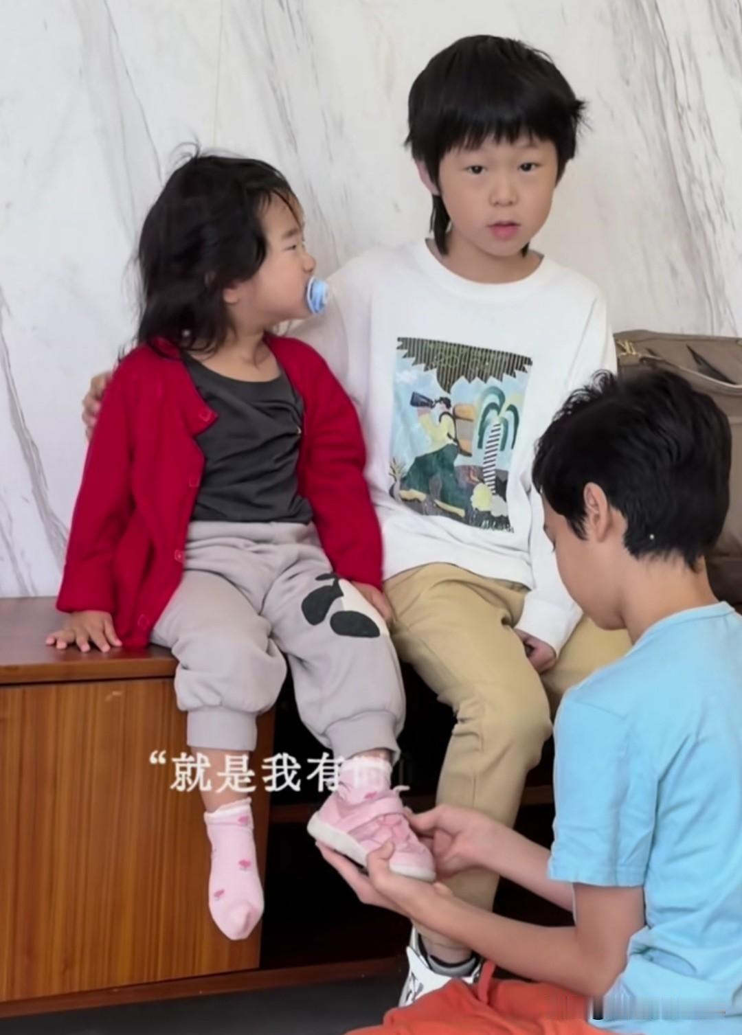 张纪中导演家的大儿子马丁太有当哥哥的样子了，他今天蹲在那里耐心的给小龙珠妹妹穿鞋