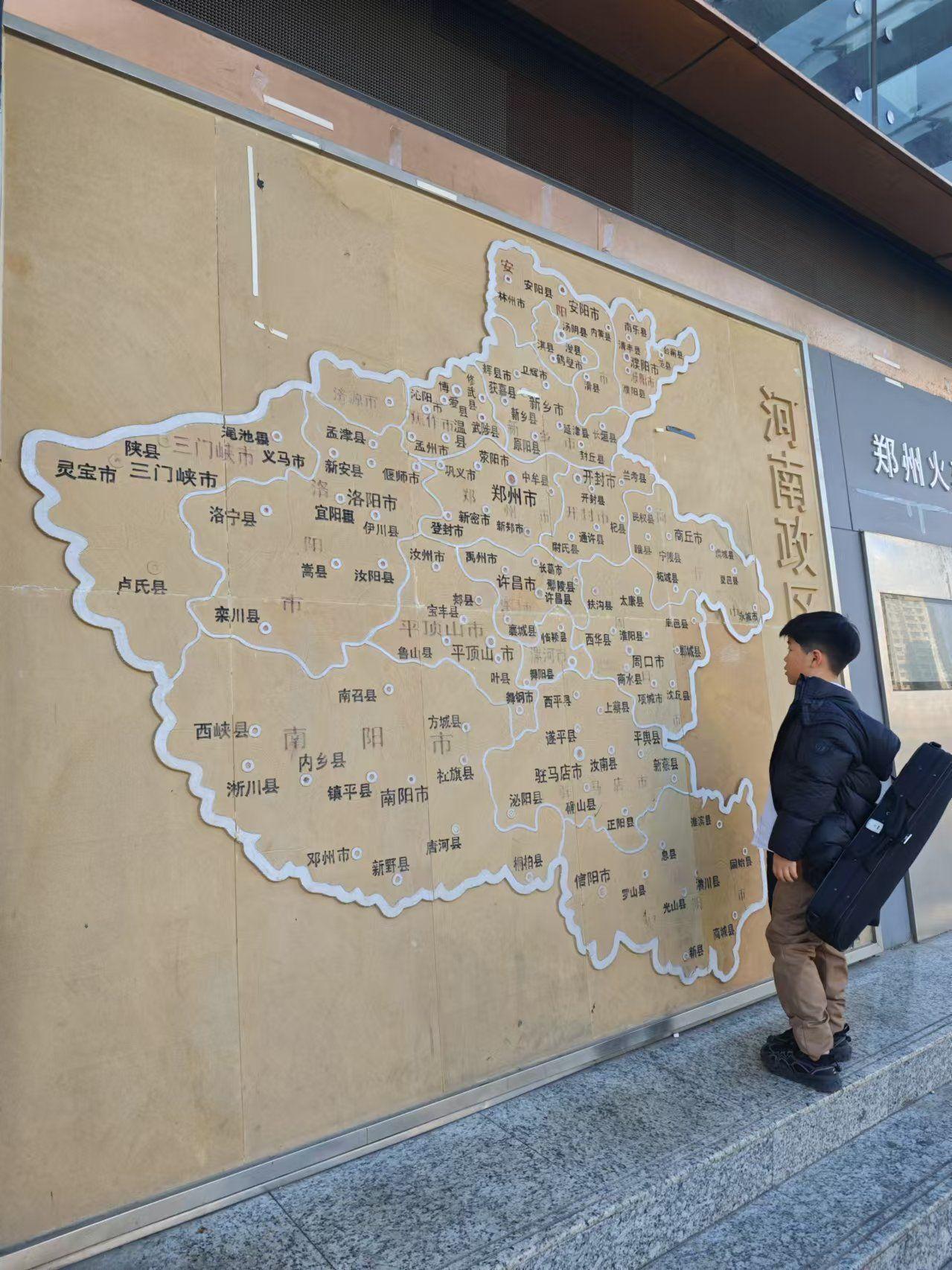 一位儿童，驻足地图前，专心凝望大中原。 ​​​