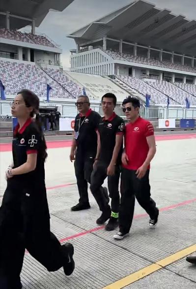 郭富城一家现身浙江宁波站赛车比赛现场，他身穿红色圆领T恤衫，黑色运动裤，从背影来