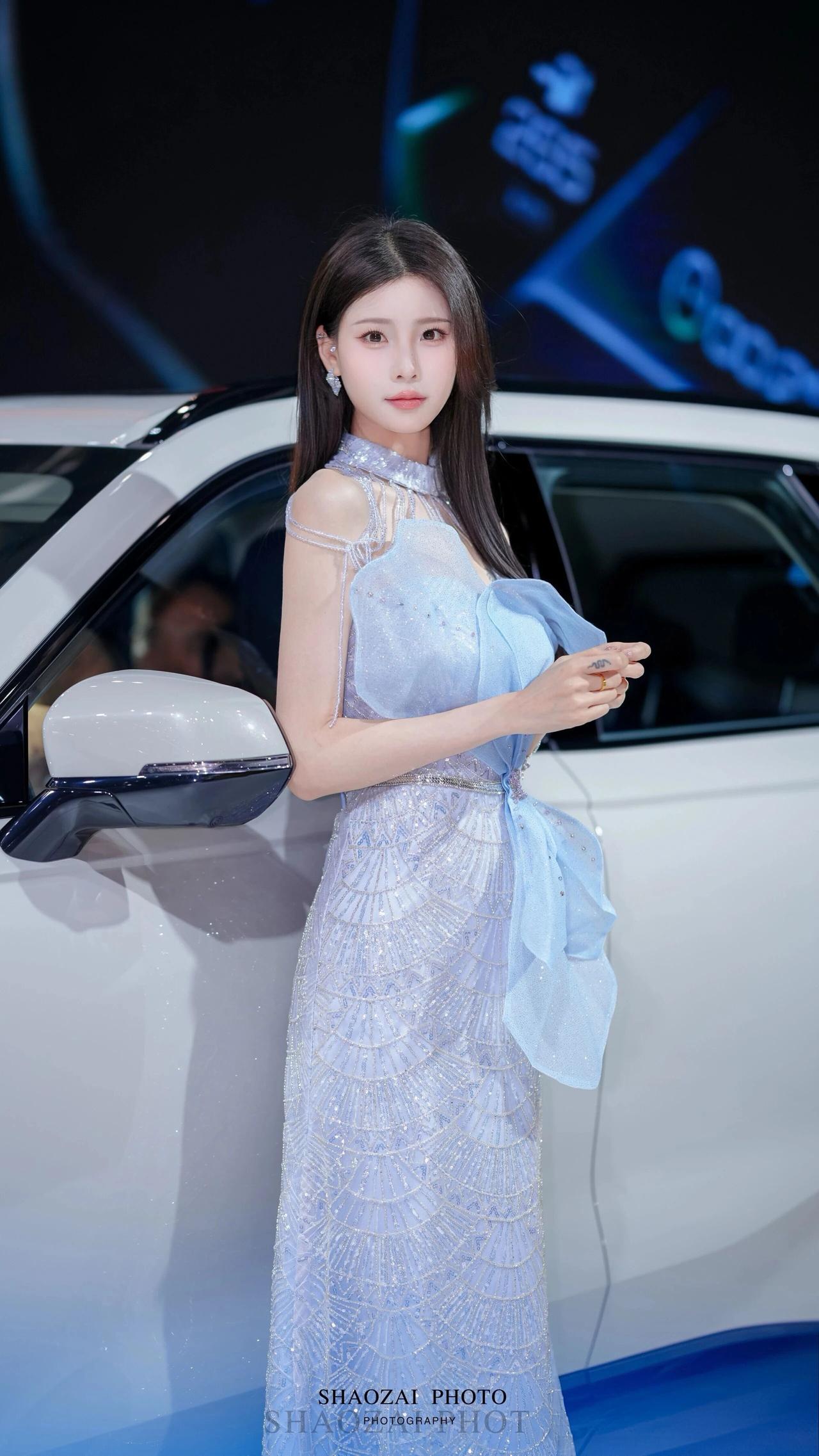 身姿纤秾合度，长发垂顺柔润，眉眼清透温婉，时而优雅倚车、时而灵动比心，自带温柔氛