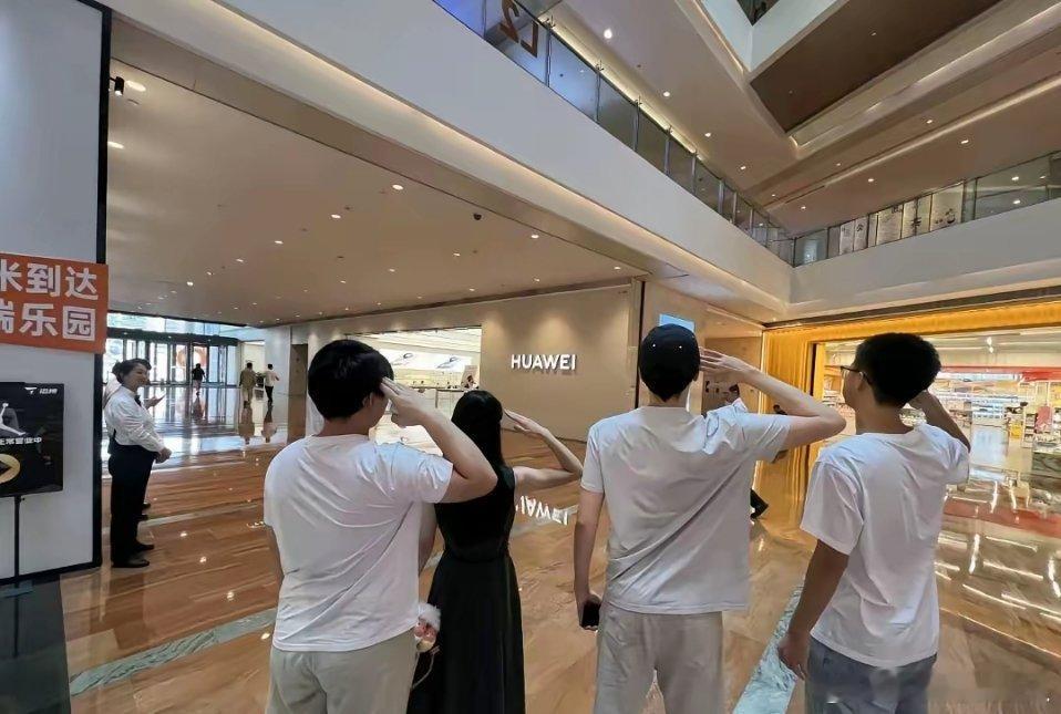最近刷到不少年轻人，还有家长带着孩子，在华为门店门口敬礼的画面，看着多少有点摸不