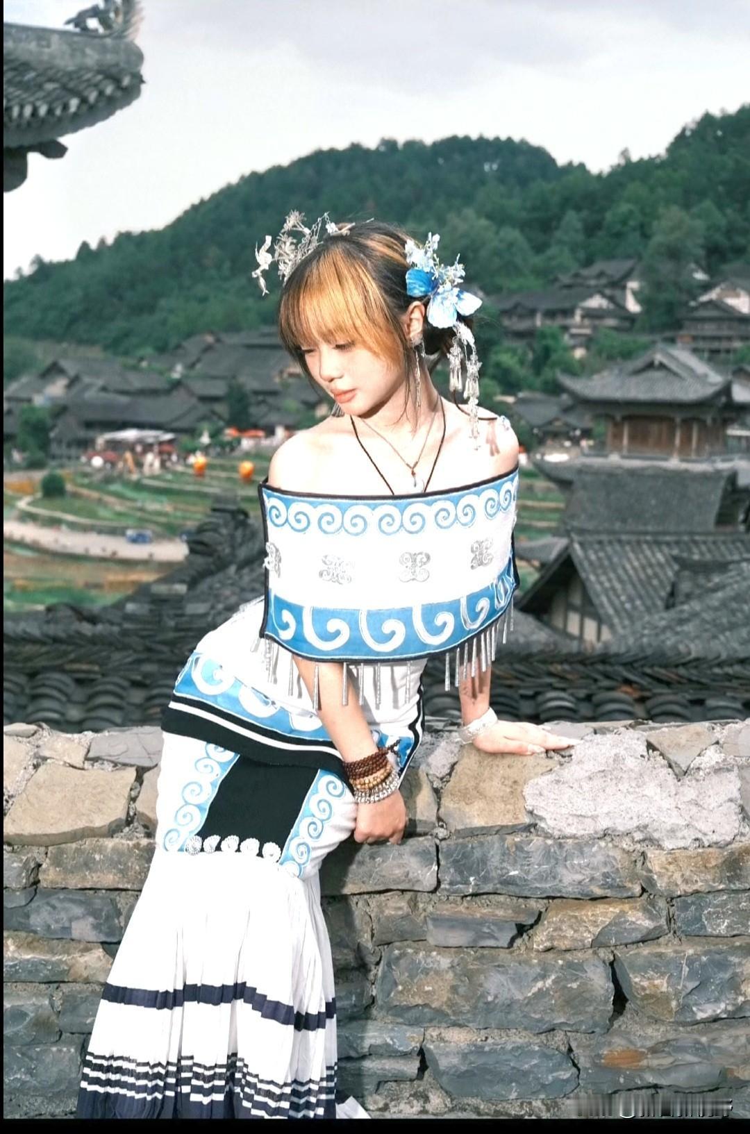 穿着民族服装的女孩靠在石墙上分享一张相册里随手拍的天空 民族姑娘自拍 石阶上的女