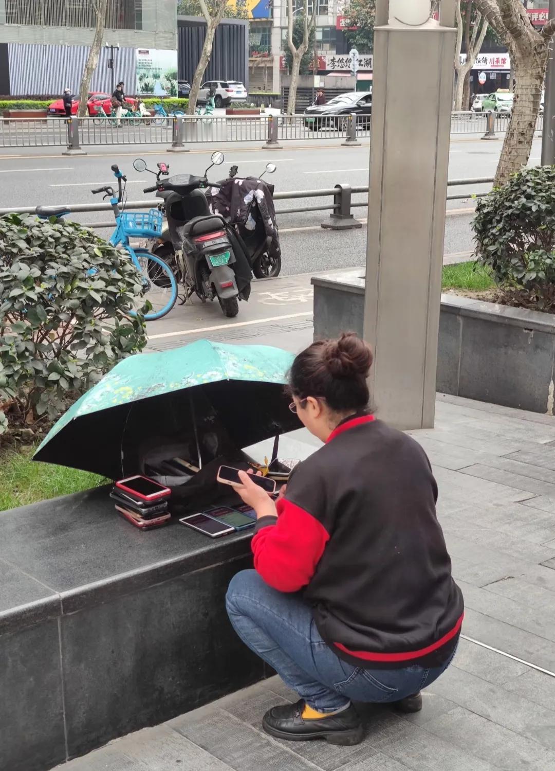街头偶遇一位大姐摆弄着十几部手机，神情专注地来回切换操作，也不像卖旧手机的，实在