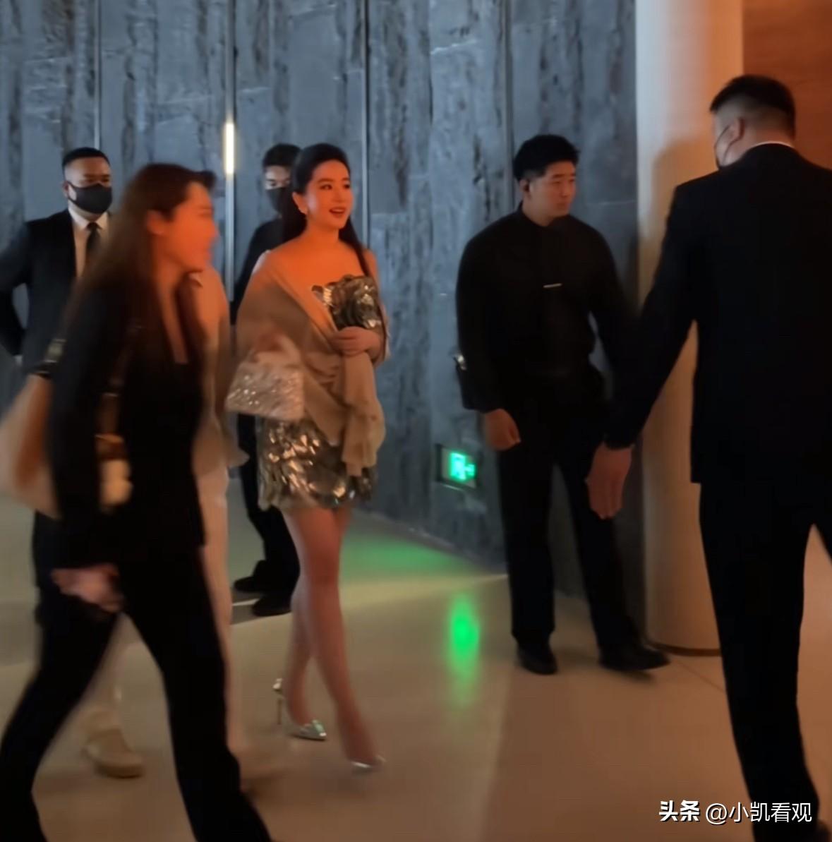 在一场高端活动的现场，女星刘亦菲身着闪亮短裙，搭配精致披肩，优雅地穿梭在人群中。