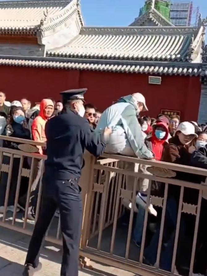 五台山游客插队直接被拎了出来 近日，五台山景区一名游客因插队被工作人员当场“拎出