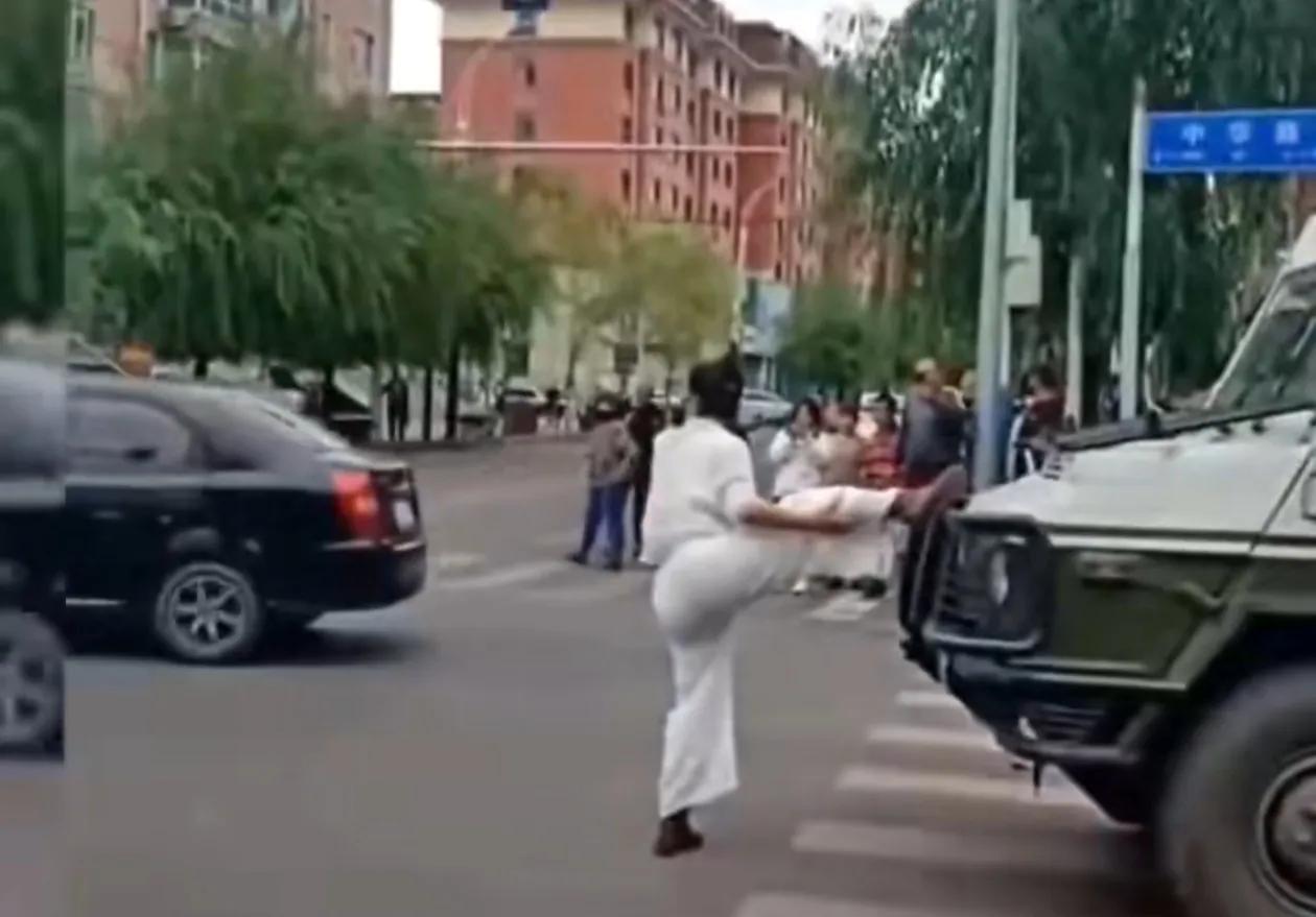 正常人干不出这事，这女人一定有精神病。大街上，一白衣女子拦在武警的车前面，脚踩车