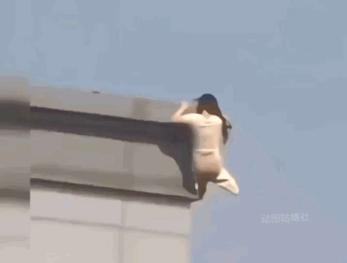 太吓人了！
一位穿粉色裙子长发女孩想轻生，爬上高楼大厦一角墙外侧，正想松手跳下去