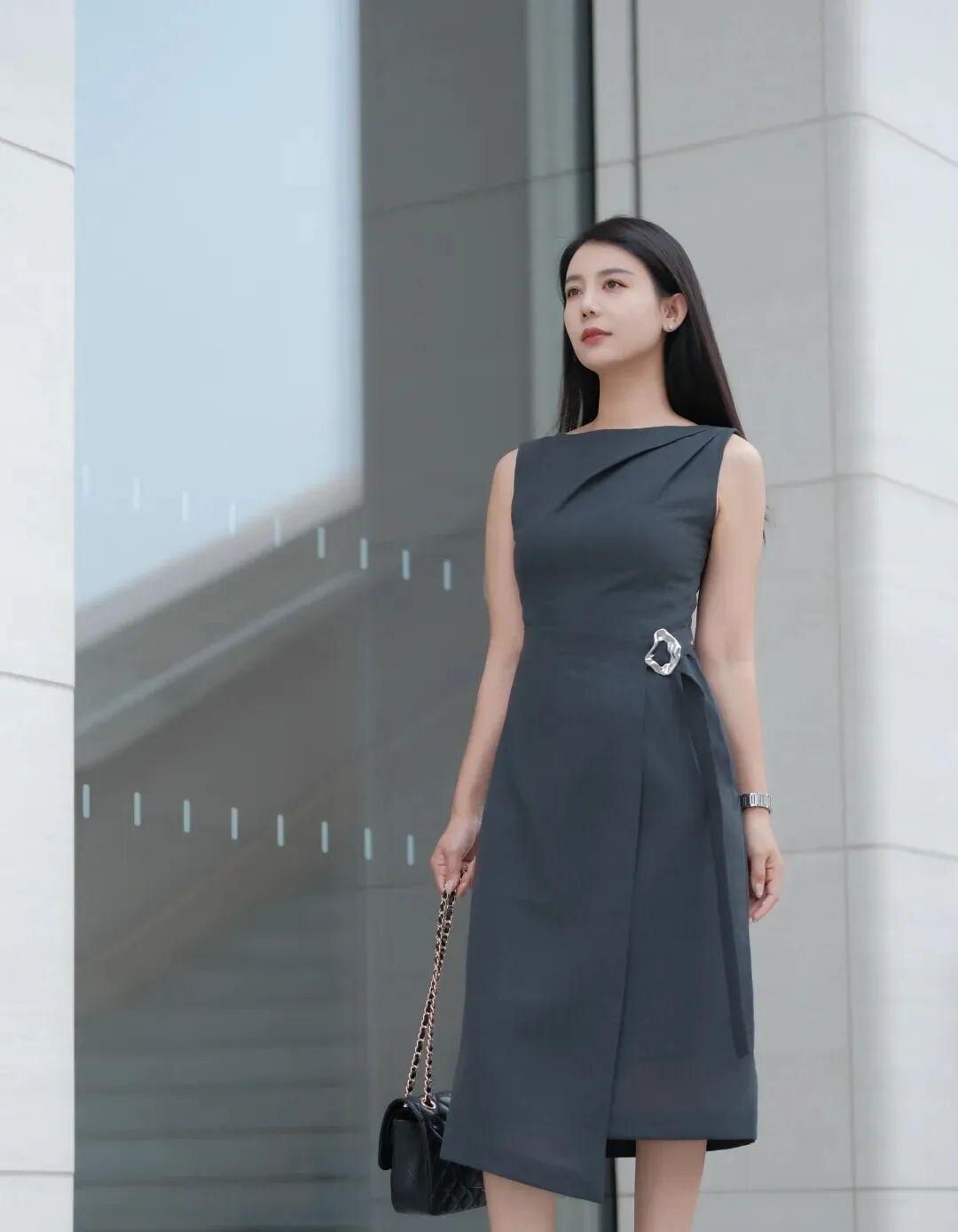 穿灰色连衣裙的女士站在建筑旁。