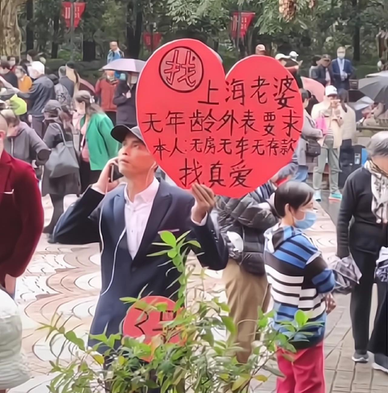 大哥在相亲角举着爱心牌子，目标很明确，就找上海老婆，长相年纪全都不挑，自己坦诚：