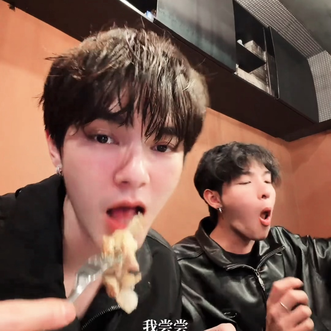 何伟身后有只小猪又在吃饭吃得舔手指